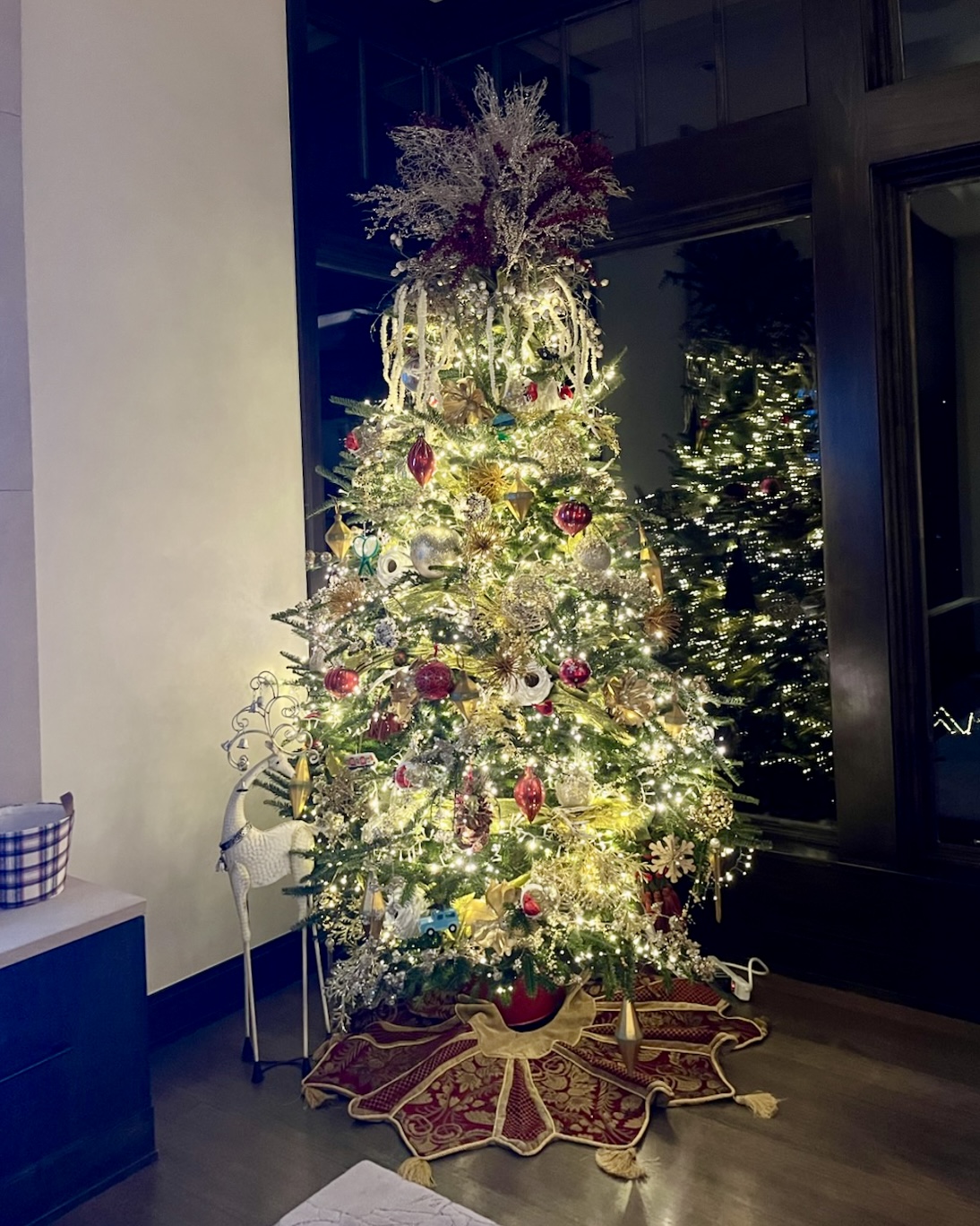 A Christmas tree glowing in gold and burgundy, styled by Marina Johnston Interior Design